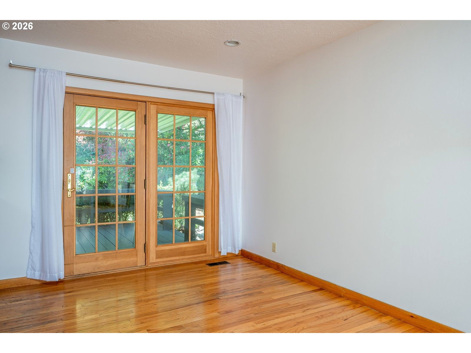 5815 Southwest Huddleson Street Portland, OR 97219 - Photo 10 of 35 a view of an empty room with wooden floor and a window