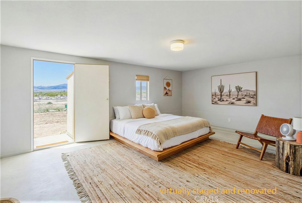 5828 Steeg Road Twentynine Palms, CA 92277 - Photo 29 of 66 a bedroom with a bed a window and chair