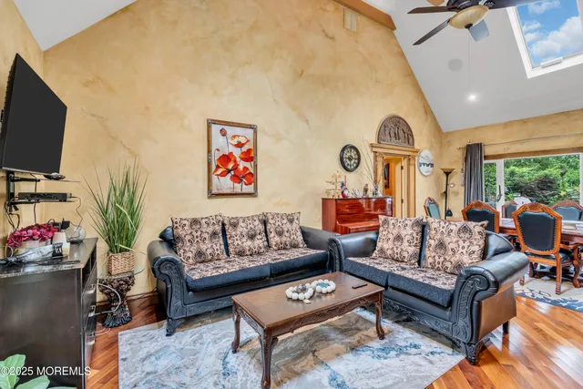 a living room with furniture flat screen tv and a large window