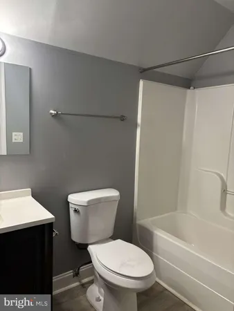 a white toilet sitting next to a bath tub