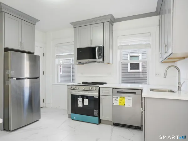 a kitchen with stainless steel appliances kitchen island a stove and a refrigerator