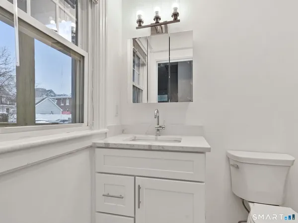 a bathroom with a sink a toilet and mirror