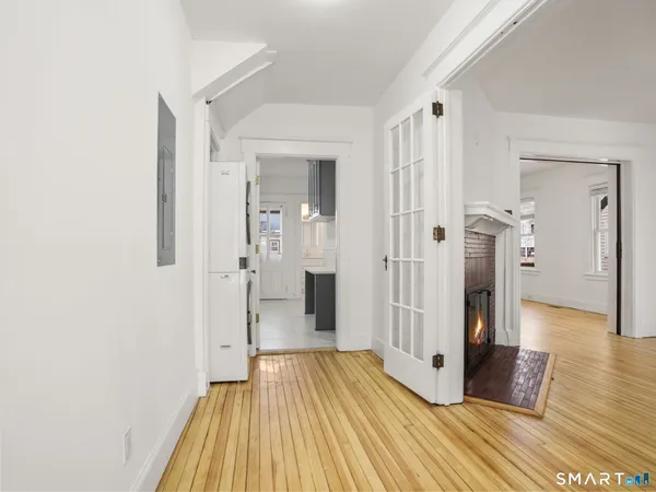 a view of a hallway with wooden floor and staircase