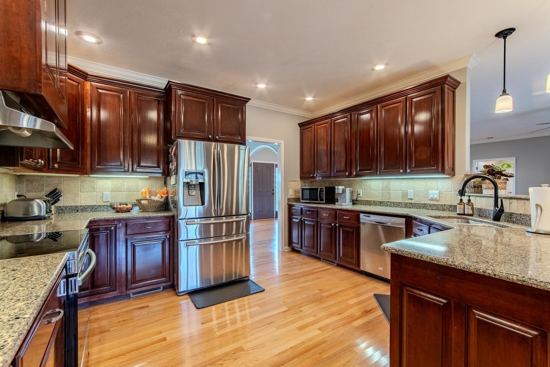 2705 Oak Grove Road Savannah, TN 38372 - Photo 2 of 40 a kitchen with stainless steel appliances granite countertop a refrigerator a sink dishwasher a stove with wooden cabinets and floor