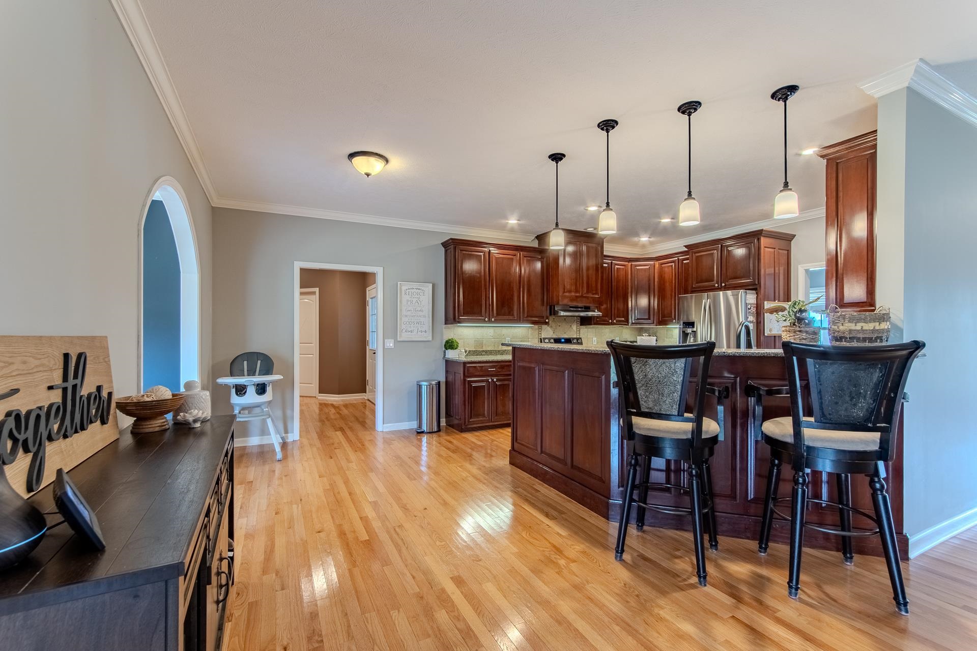 2705 Oak Grove Road Savannah, TN 38372 - Photo 7 of 40 a kitchen with stainless steel appliances kitchen island granite countertop a stove a refrigerator a kitchen island a dining table and chairs with wooden floor