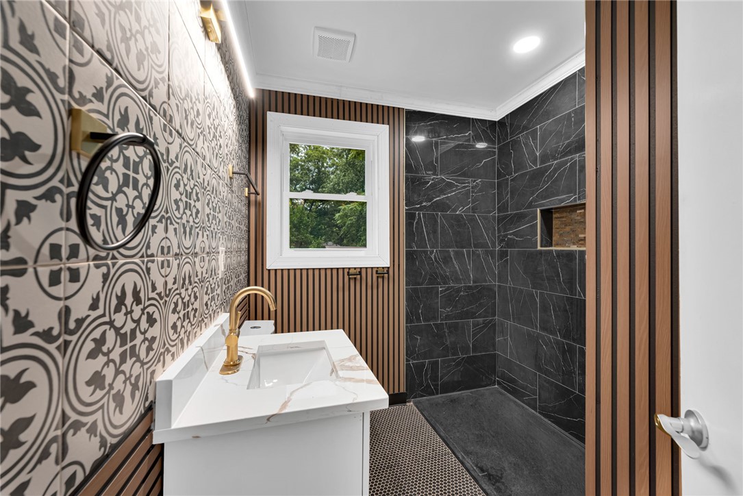1010 Log Shoals Road Mauldin, SC 29662 - Photo 19 of 28 Modern bathroom featuring patterned wall tiles and a sleek walk-in shower with dark marble.