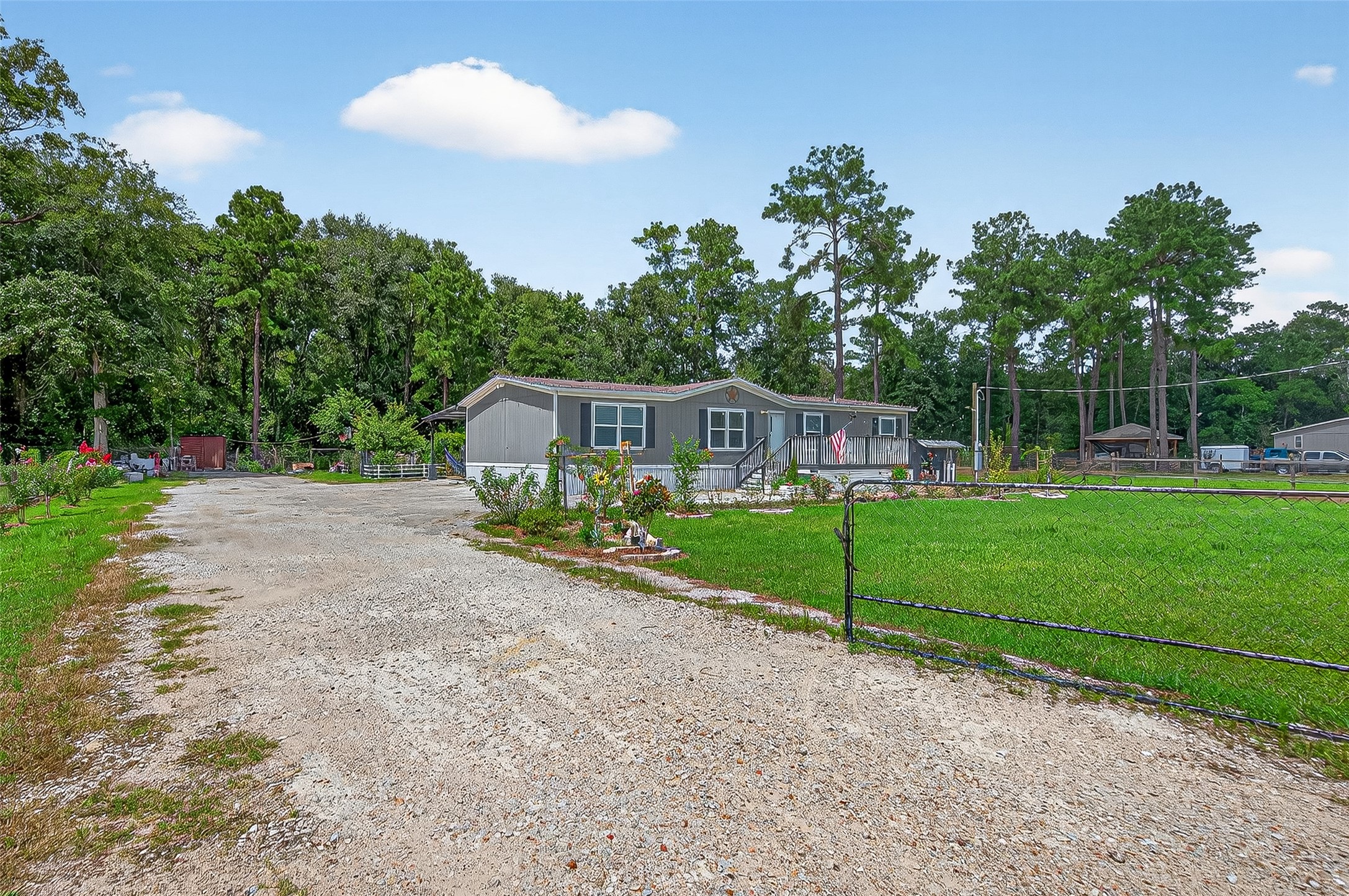 12514 County Road 3740 Cleveland, TX 77327 - Photo 3 of 31 a front view of a house with a yard and potted plants