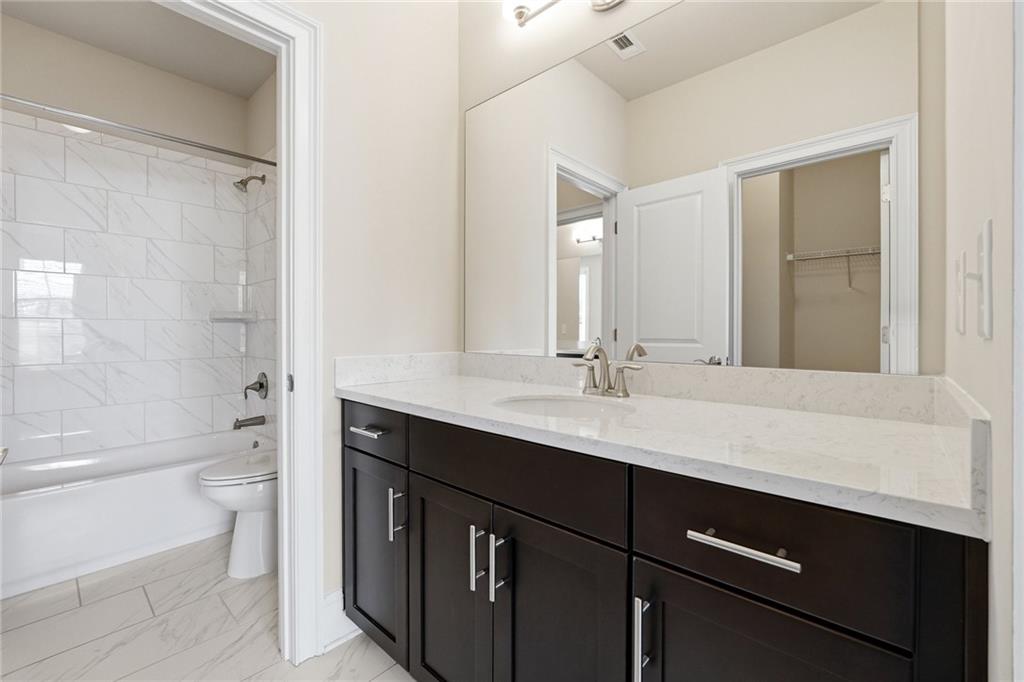 1810 Geranium Lane Cumming, GA 30040 - Photo 11 of 37 a bathroom with a double vanity sink toilet mirror and bathtub