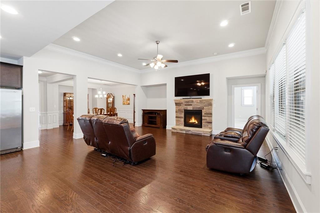 1810 Geranium Lane Cumming, GA 30040 - Photo 2 of 37 a living room with furniture a fireplace a flat screen tv and kitchen view
