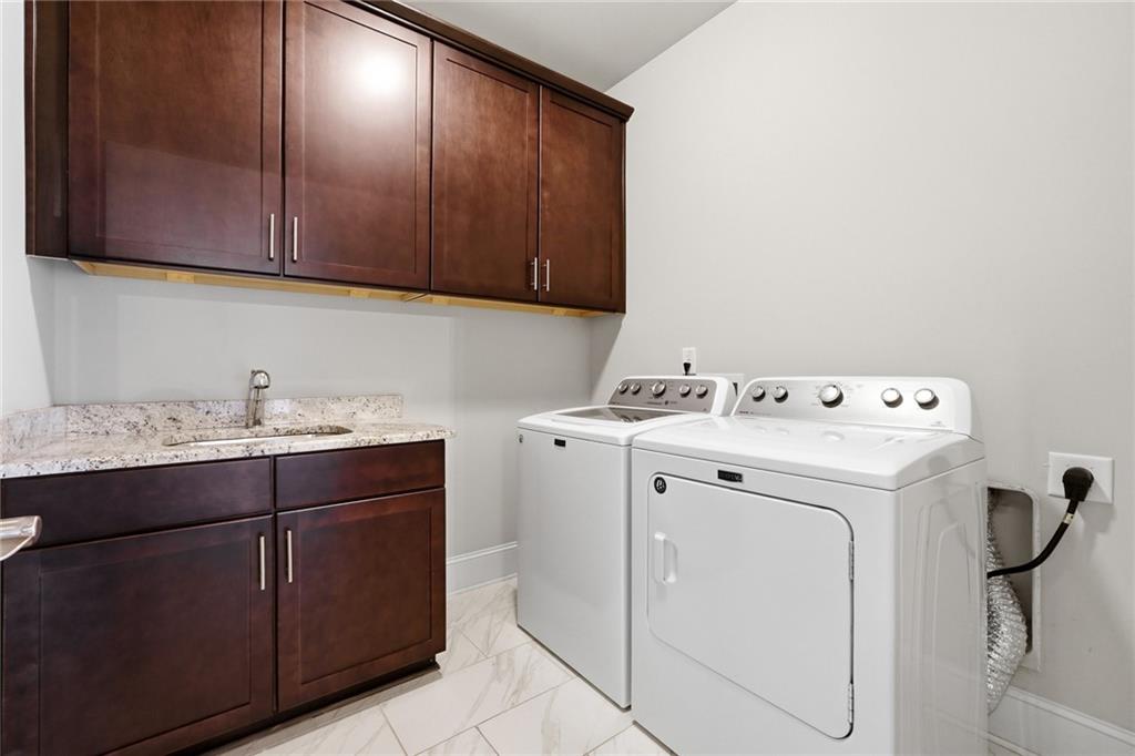 1810 Geranium Lane Cumming, GA 30040 - Photo 25 of 37 a utility room with cabinets washer and dryer