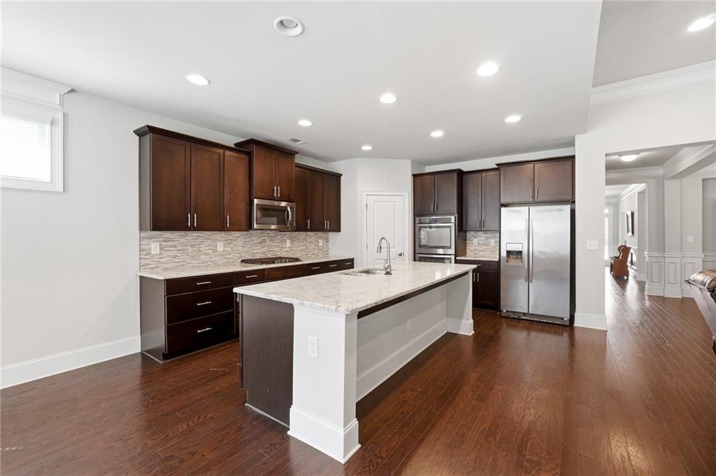 1810 Geranium Lane Cumming, GA 30040 - Photo 3 of 37 a large kitchen with stainless steel appliances granite countertop a stove a sink dishwasher and a refrigerator with wooden floor