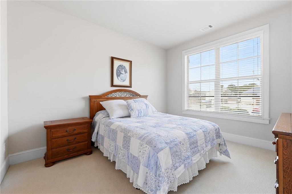 1810 Geranium Lane Cumming, GA 30040 - Photo 10 of 37 a bedroom with a bed a dresser and a window