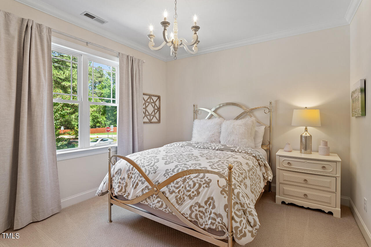 2016 Brassfield Road Raleigh, NC 27614 - Photo 24 of 44 a bedroom with a bed a chandelier and a window