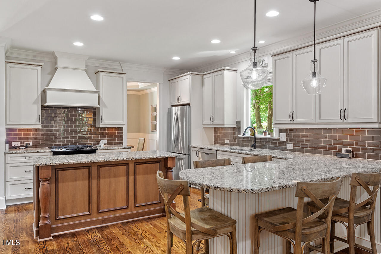 2016 Brassfield Road Raleigh, NC 27614 - Photo 10 of 44 a kitchen with granite countertop a sink chairs and wooden cabinets