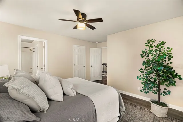 a bedroom with a large bed and a potted plant