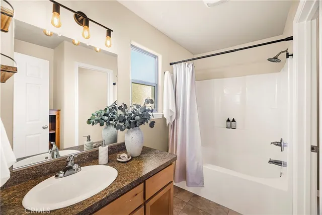 a bathroom with a granite countertop shower sink and mirror