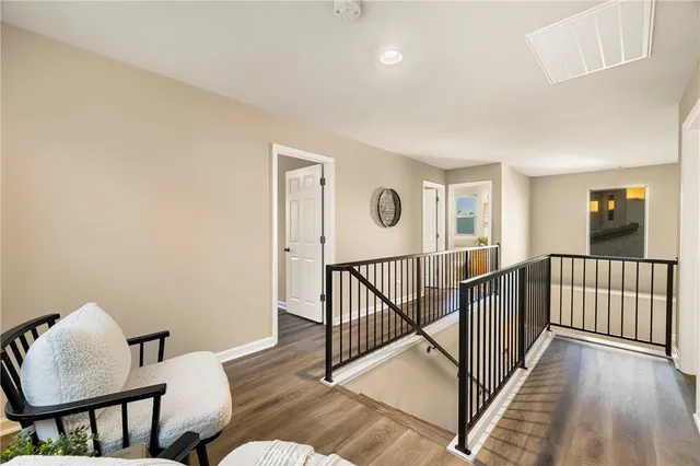 a view of a hallway with wooden floor and stairs