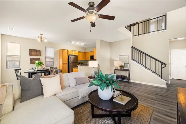 a living room with furniture kitchen view and a potted plant