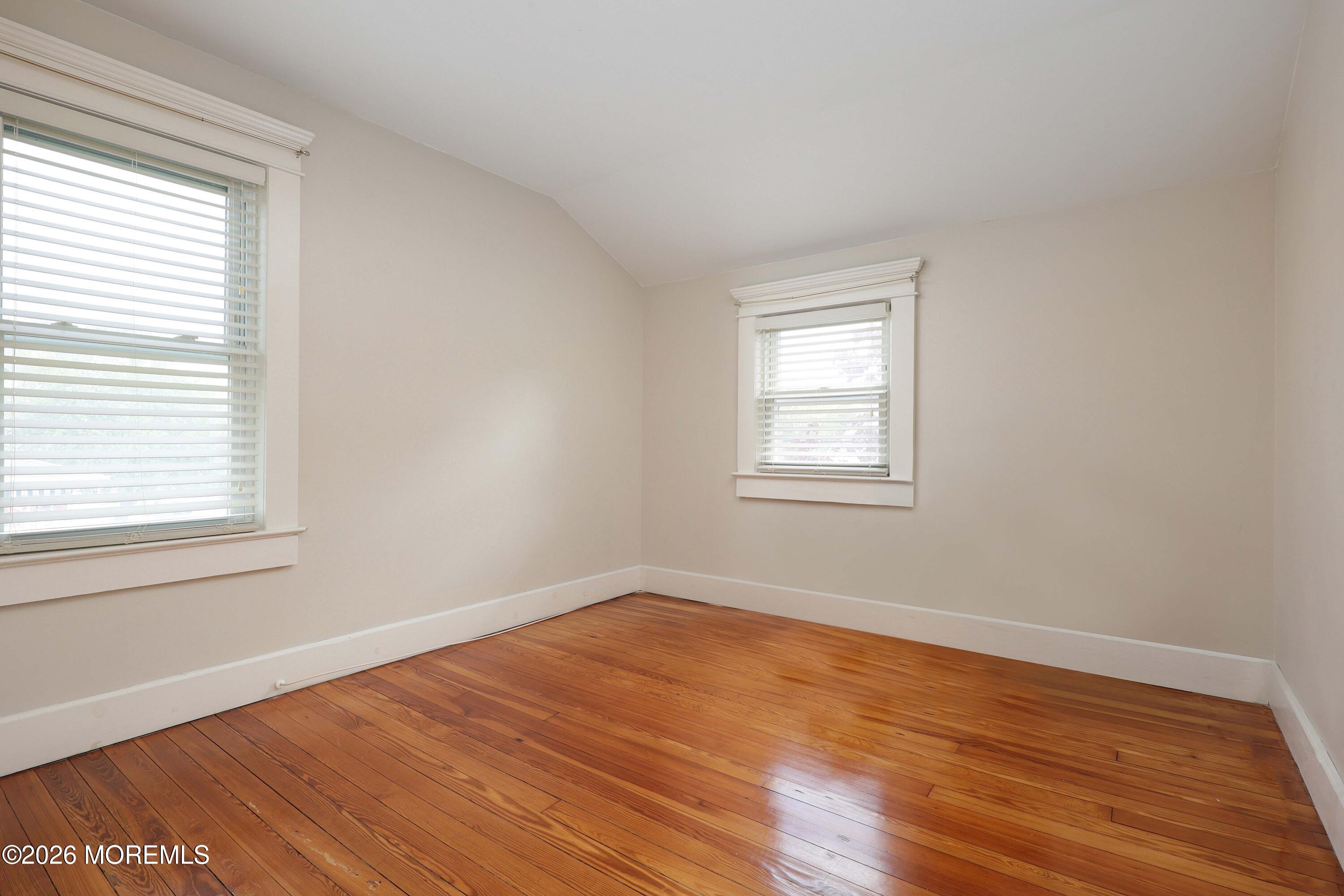 715 Howe Street Point Pleasant, NJ 08742 - Photo 19 of 45 an empty room with wooden floor and windows