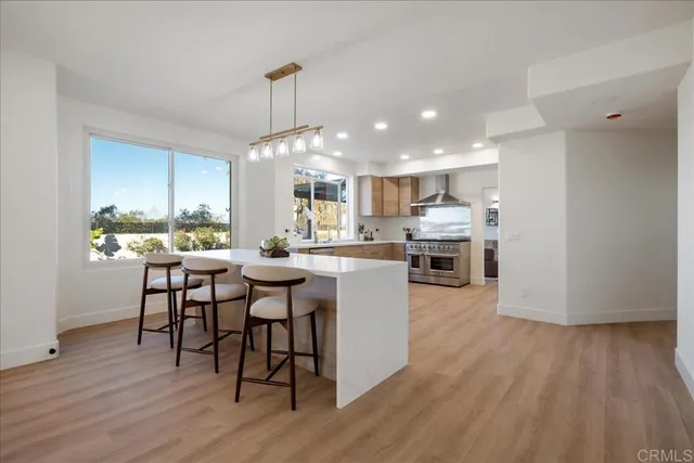 a kitchen with stainless steel appliances granite countertop wooden floor dining table and chairs