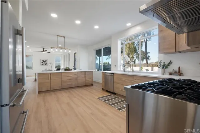 a kitchen with kitchen island stainless steel appliances a sink cabinets and a counter top space