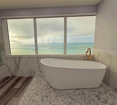 a white bath tub sitting in a bathroom next to a window