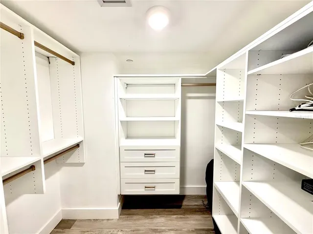a view of walk in closet with empty racks