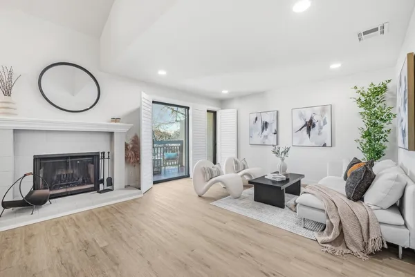 a living room with furniture a fireplace and a large window