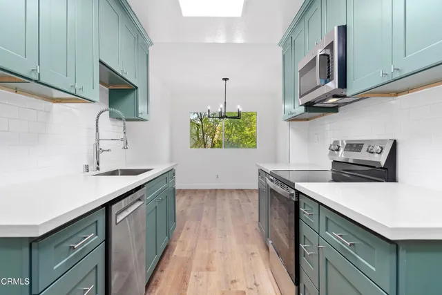 a kitchen with stainless steel appliances granite countertop a sink a stove and a microwave oven