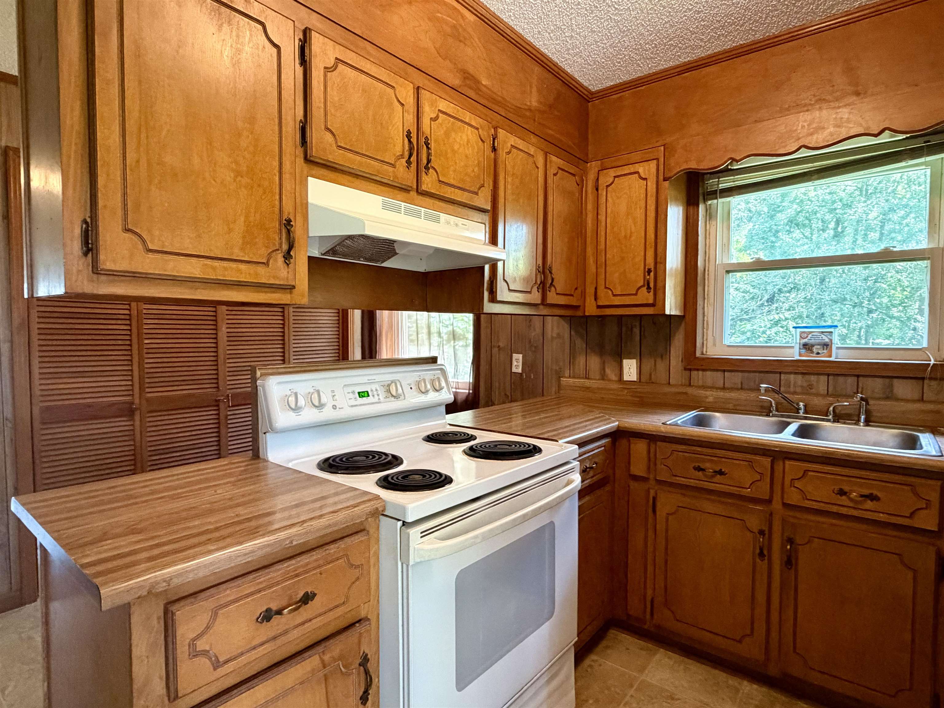355 Purdy Road Selmer, TN 38375 - Photo 5 of 14 Kitchen featuring wood-finish cabinetry, a white electric range, and a double basin stainless steel sink