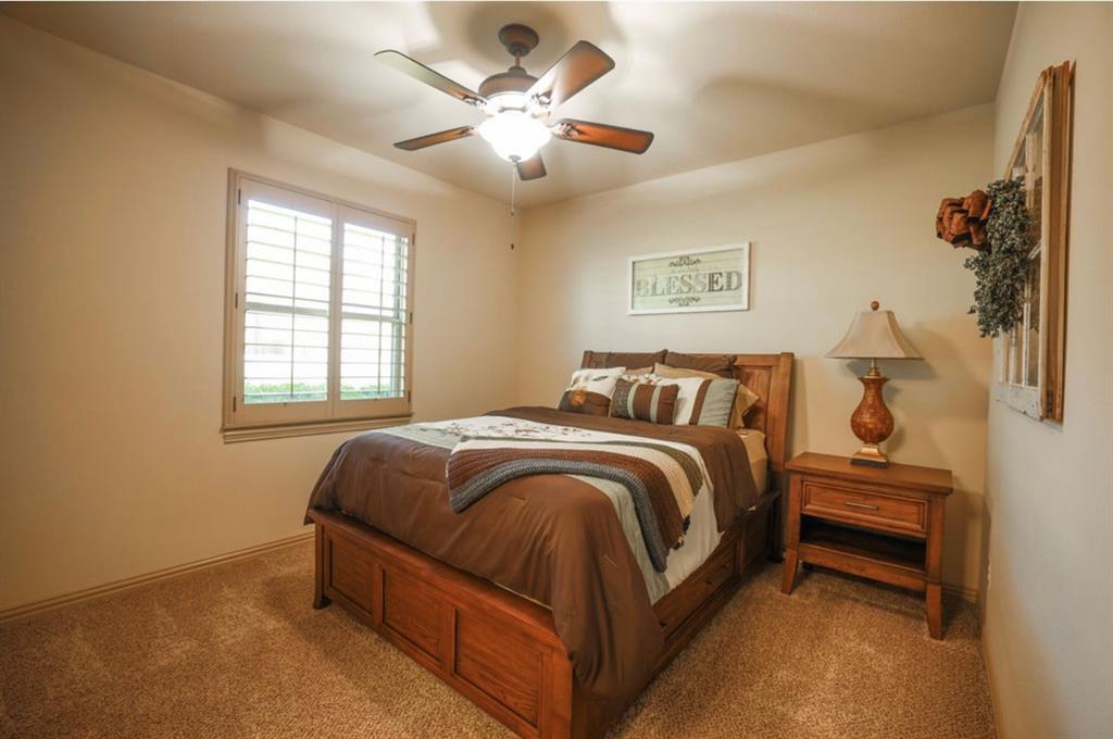 1387 Shadow Lakes Drive Wills Point, TX 75169 - Photo 23 of 33 a spacious bedroom with a bed and a chandelier