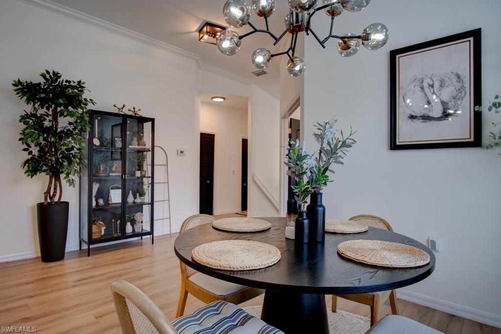 1969 Crestview Way, Unit 152 Naples, FL 34119 - Photo 11 of 35 a view of a dining room with furniture and wooden floor