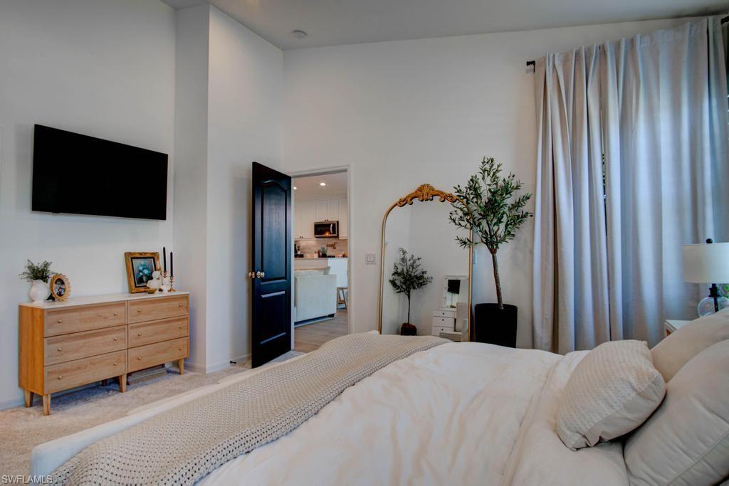 1969 Crestview Way, Unit 152 Naples, FL 34119 - Photo 15 of 35 a bedroom with a bed and a flat tv screen on dresser