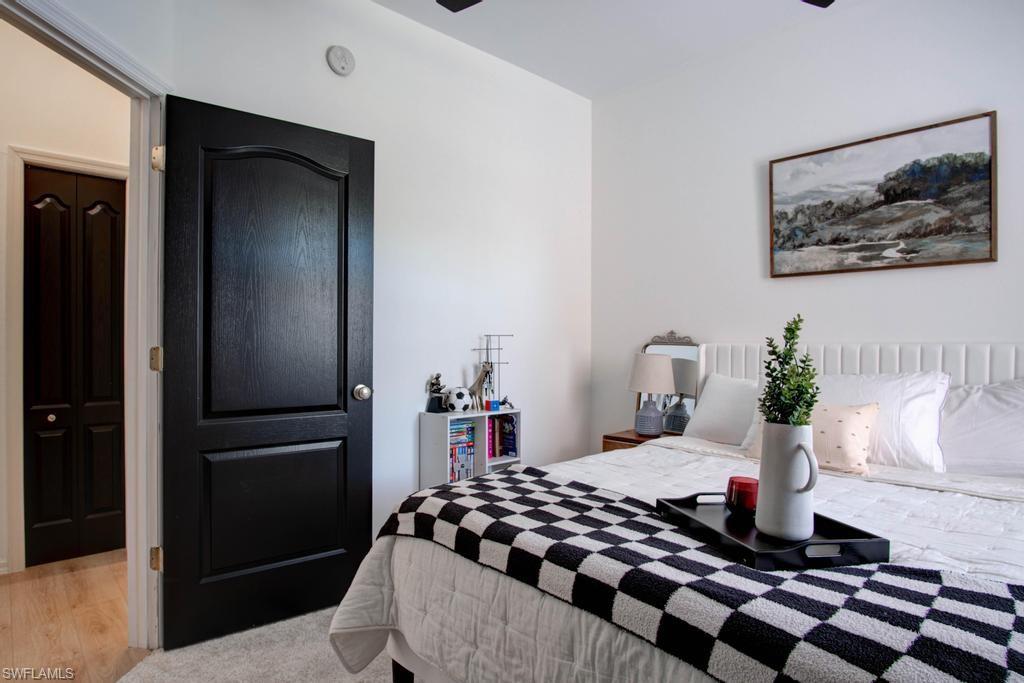 1969 Crestview Way, Unit 152 Naples, FL 34119 - Photo 25 of 35 a bedroom with a bed and a painting on the wall
