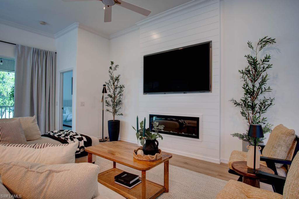 1969 Crestview Way, Unit 152 Naples, FL 34119 - Photo 5 of 35 a living room with furniture a flat screen tv and a fireplace