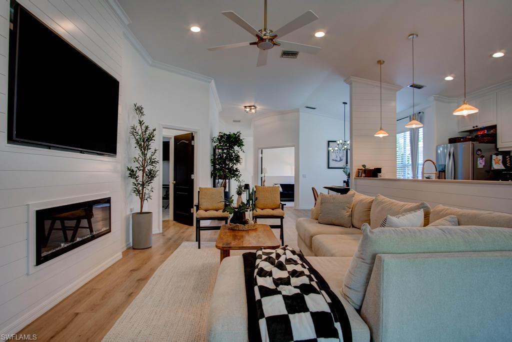 1969 Crestview Way, Unit 152 Naples, FL 34119 - Photo 6 of 35 a living room with furniture a flat screen tv and a fireplace