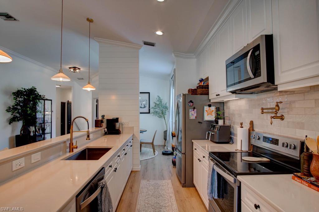 1969 Crestview Way, Unit 152 Naples, FL 34119 - Photo 8 of 35 a kitchen with granite countertop a stove and a sink