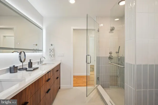 a bathroom with a granite countertop sink mirror and shower