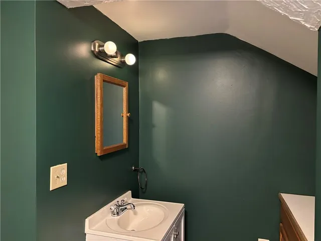 a bathroom with a toilet sink vanity and mirror