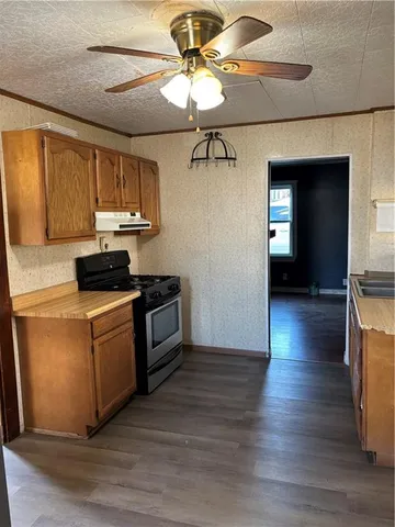 a kitchen with a stove cabinets and wooden floor