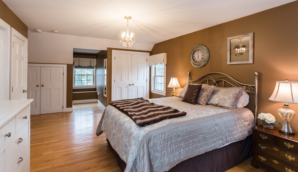 23 Mayflower Road Needham, MA 02492 - Photo 13 of 17 a bedroom with a bed and a chandelier