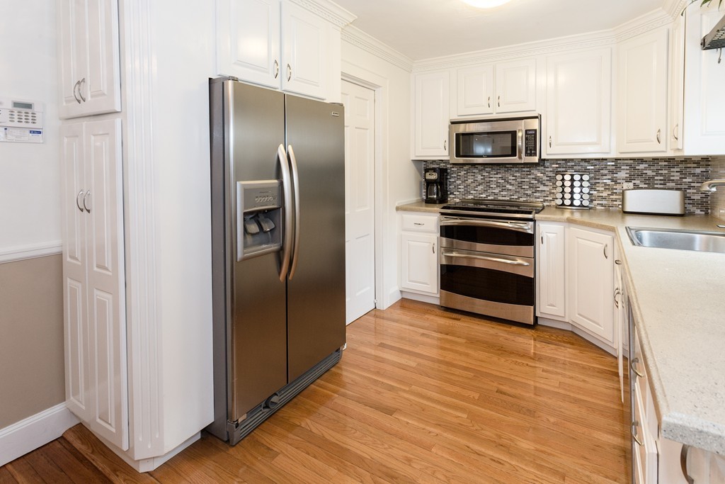 23 Mayflower Road Needham, MA 02492 - Photo 3 of 17 a kitchen with granite countertop a refrigerator and a stove top oven