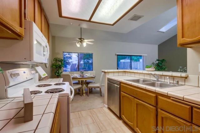 a kitchen with furniture a counter space a sink stainless steel appliances and cabinets