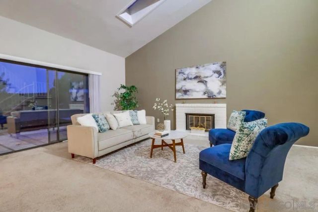 a living room with furniture a fireplace and a potted plant