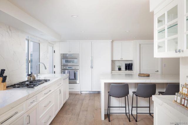 a kitchen with stainless steel appliances a stove a sink cabinets and a refrigerator