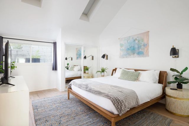 a bedroom with a large bed and a potted plant