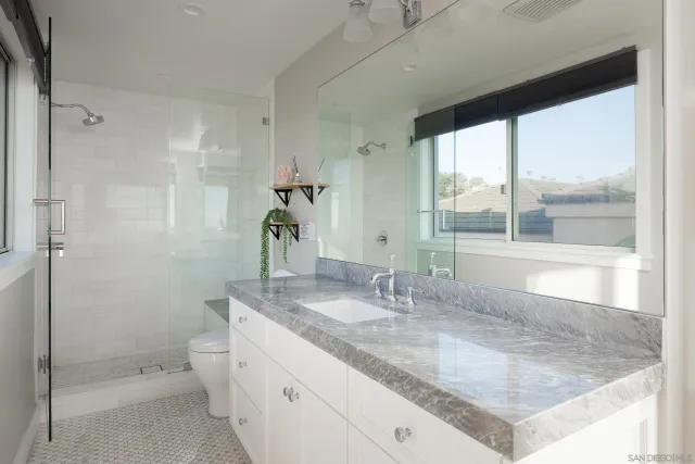 a bathroom with a granite countertop sink and a mirror