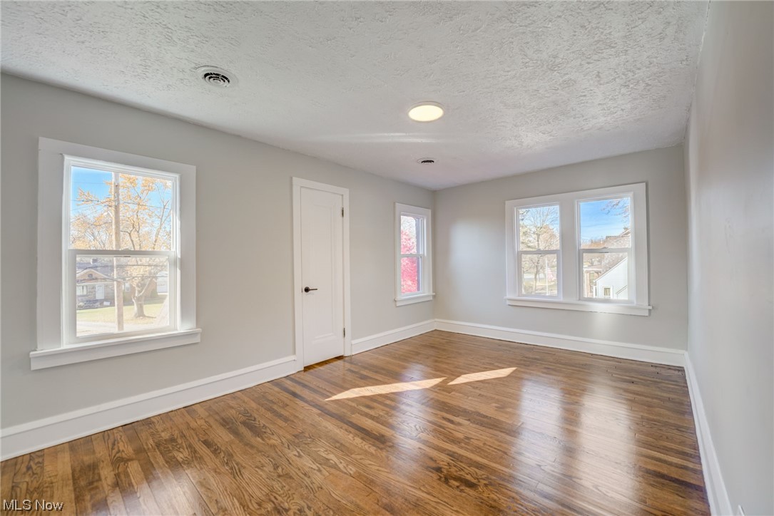 6197 Turney Road Cleveland, OH 44125 - Photo 17 of 35 Unfurnished room with a textured ceiling and dark hardwood / wood-style flooring