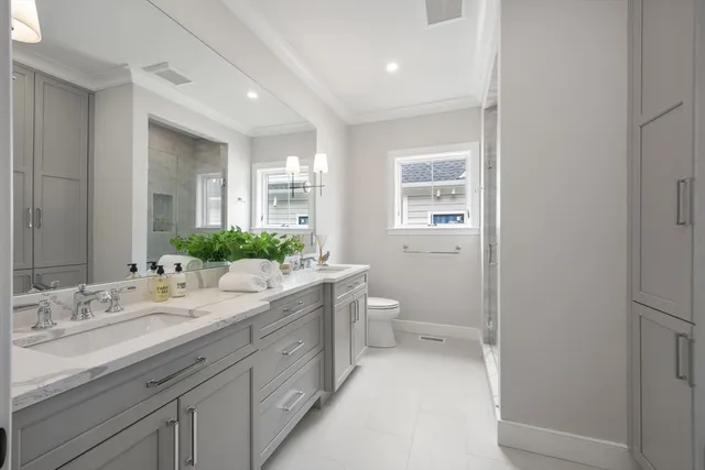 a spacious bathroom with a granite countertop sink a toilet and a mirror