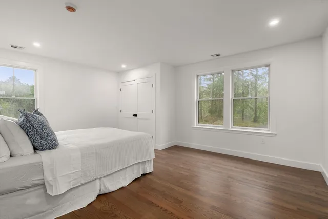 a bedroom with a bed and a large window